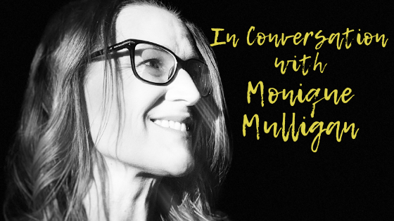 ID: Black-and-white headshot of author Monique Mulligan. She is wearing glasses and smiling at something off-camera. In yellow are the words, "In Conversation with Monique Mulligan".