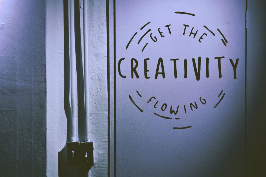 ID: a plain wall and door, with the words, "Get the Creativity Flowing" in marker pen on the door.